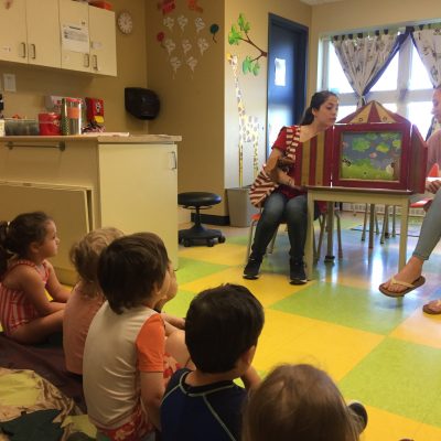 Des animatrices font la lecture de kamishibaï à des enfants.